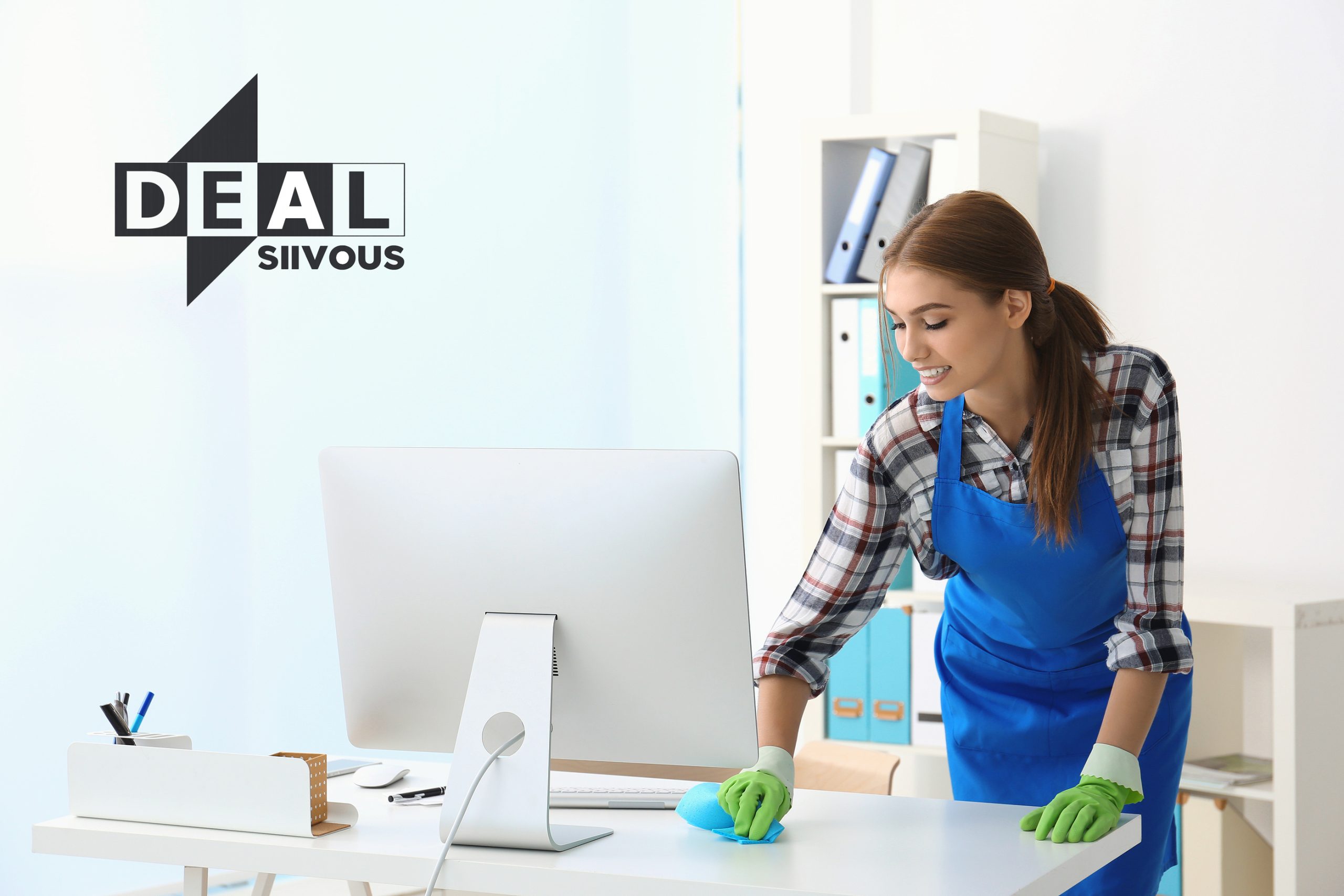 Nuori siivooja pyyhkimässä toimistopöytää Deal Siivous Oy:n logon vieressä modernissa toimistossa.